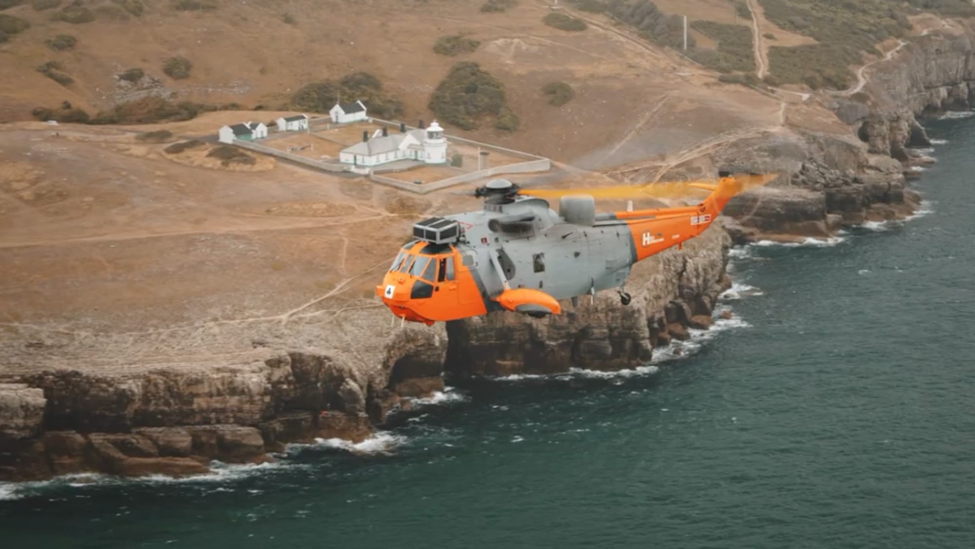A HeliOperations helicopter flying over the Portland coast